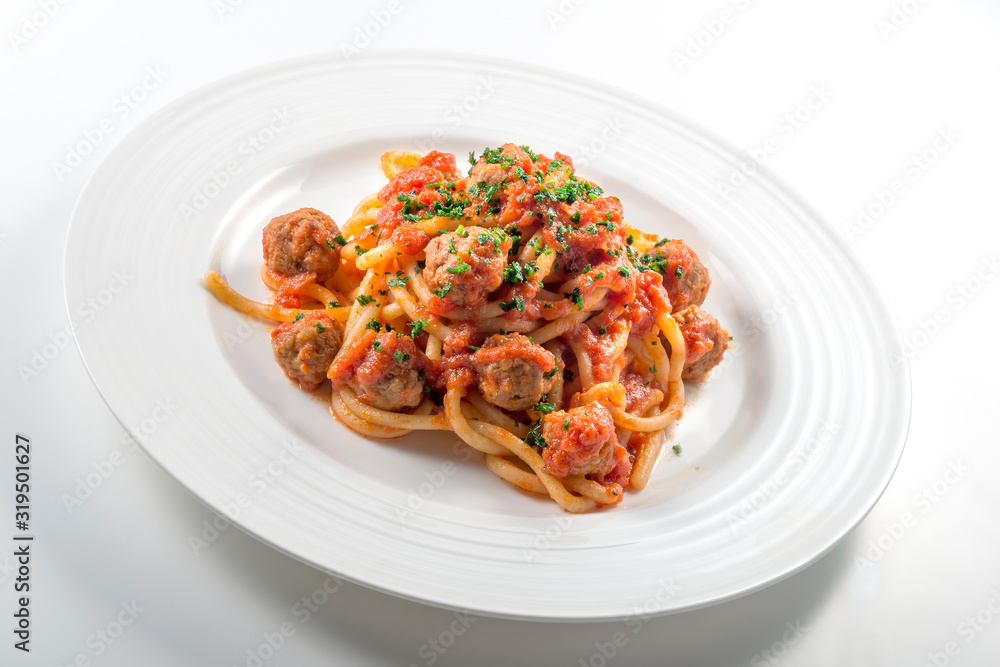 Plate of spaghetti with tomato and meatballs with chopped parsley