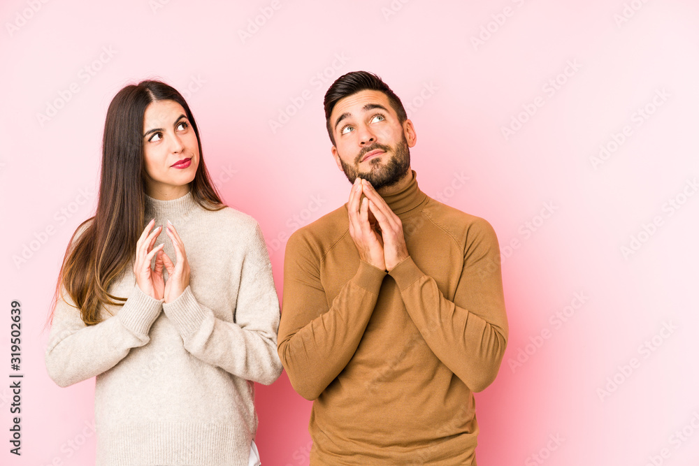 Young caucasian couple isolated making up plan in mind, setting up an idea. Young caucasian couple isolated making up plan in mind, setting up an idea.