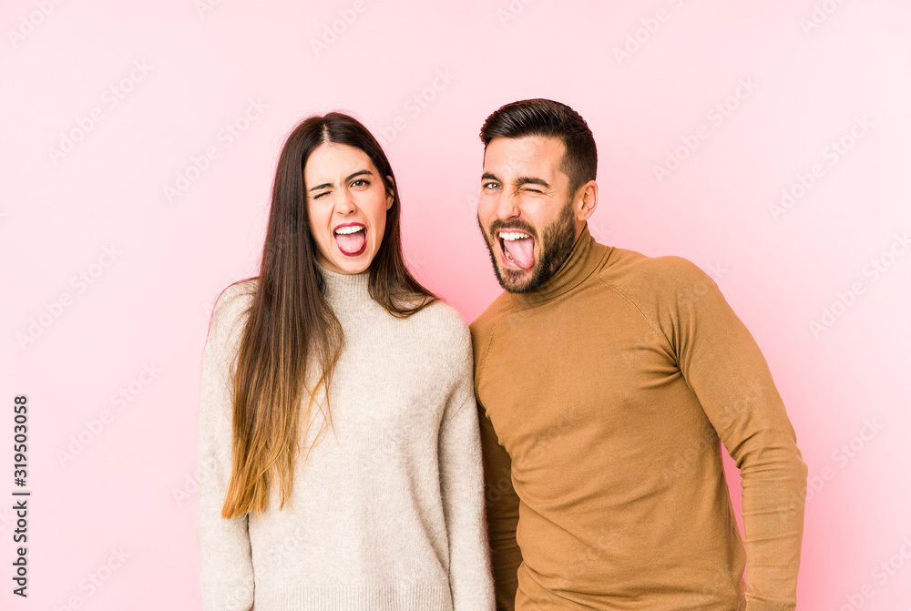 Young caucasian couple isolated funny and friendly sticking out tongue. Young caucasian couple isolated funny and friendly sticking out tongue.