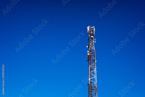 High telecommunications tower, with antennas for mobile phones creating radio cells, copy space.