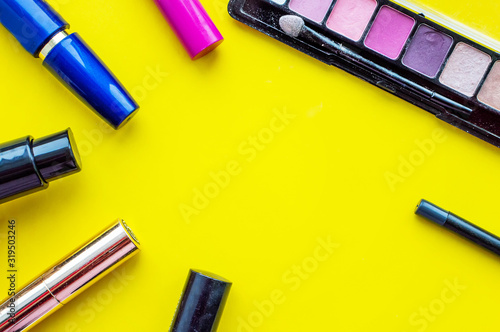 Decorative cosmetic. Mascara  lipstick  eye shadow  Foundation  eyeliner on a yellow background with a place for writing.