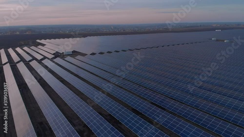 Aerial drone view into large solar panels at a solar farm at sunset. Solar cell power plants. footage video 4k.