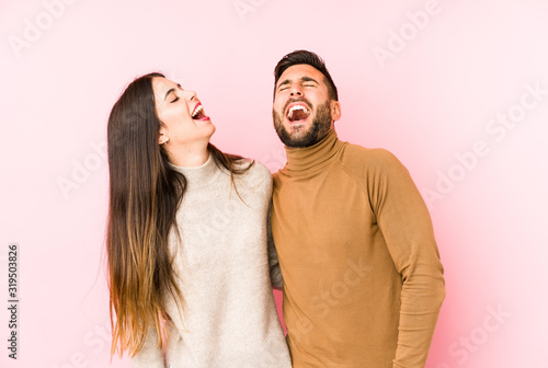 Foto Young caucasian couple isolated relaxed and happy laughing, neck stretched showing teeth