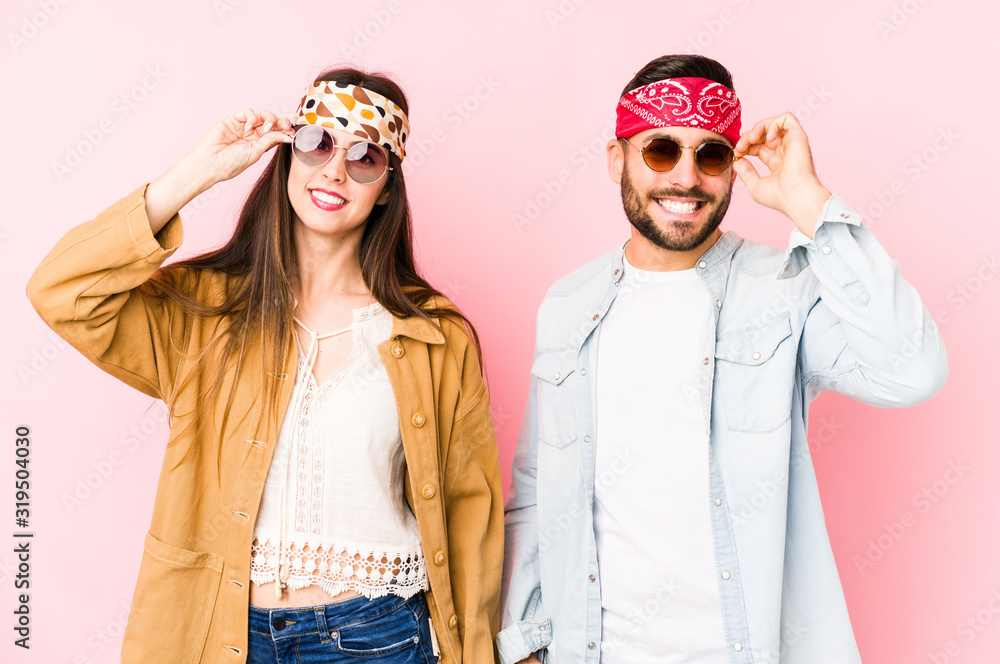 Young caucasian couple wearing a music festival clothes isolated excited keeping ok gesture on eye. Young caucasian couple wearing a music festival clothes isolated excited keeping ok gesture on eye.