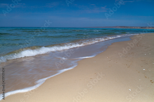 View of blue sea waves at sandy beach. Horizon line. Caspian Sea, sandstone coast. ustyurt. Selective focus, long shutter speed