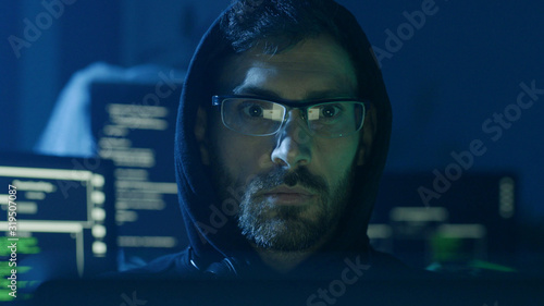 Wallpaper Mural Portrait of concentrated programmer looking at computer interface sitting at desk. Young smart man working in software development office at night. Close-up view. Torontodigital.ca