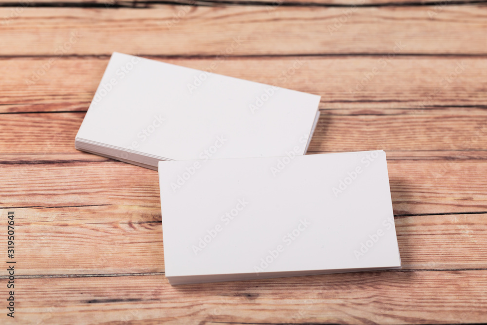 Photo of empty business cards on a light natural wooden background .. Template for identifier. Photo of empty business cards on a light natural wooden background .. Template for identifier.
