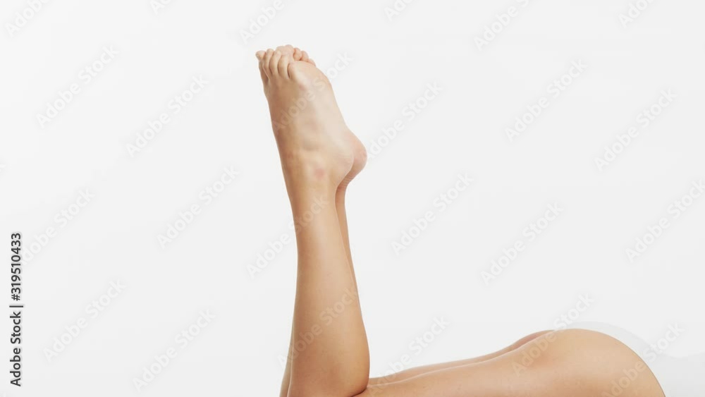 Young, beautiful, fit and natural woman in white swimsuit applying moisturizing cream. Massage, skin care, cellulite removal, sport and weight loss.