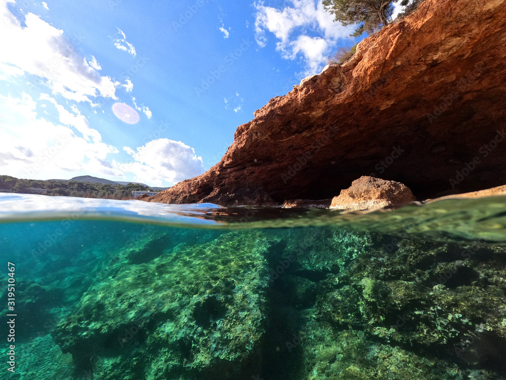 Waterline split photo of tropical exotic seascape with cave and beautiful scenery