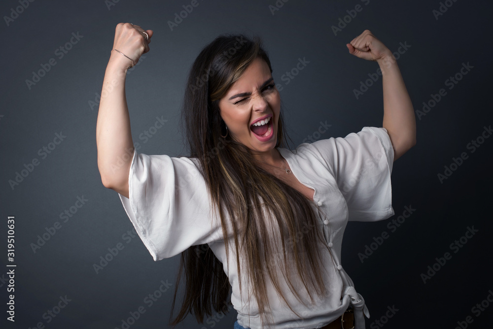 Yes I am winner. Portrait of charming delighted and excited middle aged caucasian female student raising up fist in triumph and victory smiling achieving success grinning from delight. Yes I am winner. Portrait of charming delighted and excited middle aged caucasian female student raising up fist in triumph and victory smiling achieving success grinning from delight.