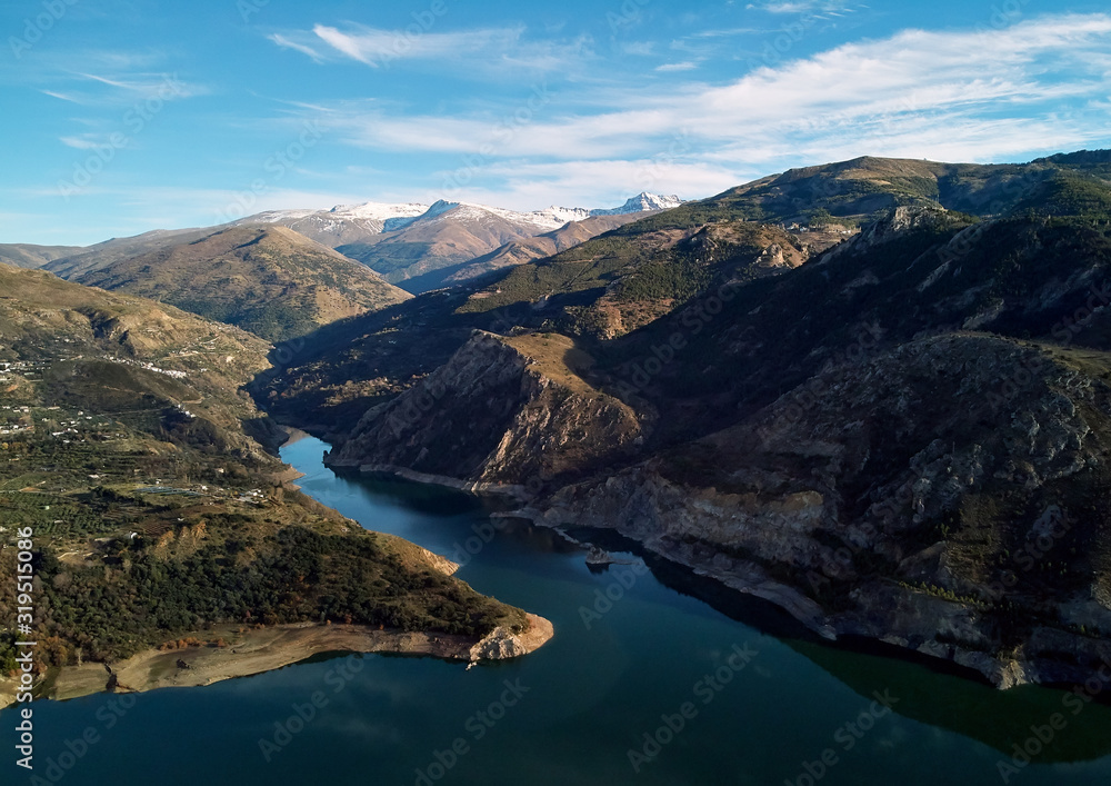 Aerial photography rocky snow-capped Sierra Nevada mountains Embalse de Canales Reservoir in Guejar Sierra, province of Granada, Andalusia, Spain. Picturesque landscape view above. Spain