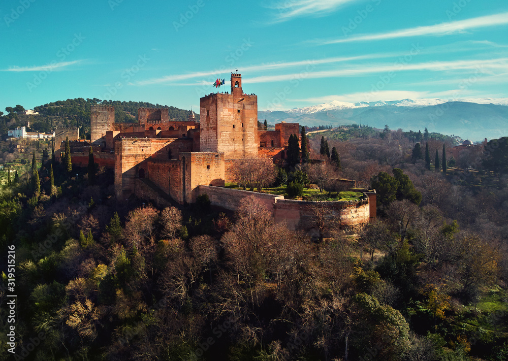 Aerial drone point of view Granada castle and surrounding lands meadows, Alhambra or Red Castle, located on top of hill al-Sabika, moorish famous place palace fortress complex in Andalusia, Spain