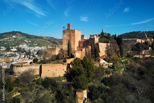 Aerial beautiful drone point of view Granada castle surrounding lands and cityscape, Alhambra or Red Castle, located on top of hill al-Sabika. Moorish palace fortress complex in Andalusia, Spain