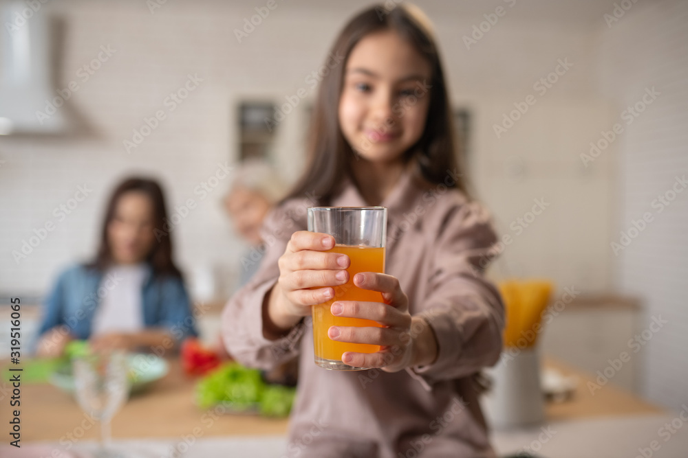 Glass of orange juice in the hands of little girl. Glass of orange juice in the hands of little girl.