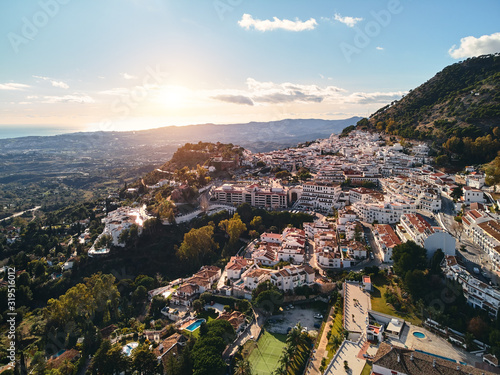 Aerial photo distant view charming Mijas pueblo, typical Andalusian white-washed mountain village, houses rooftops, small town located on hillside Province of Málaga, Costa del Sol, Europe, Spain photo