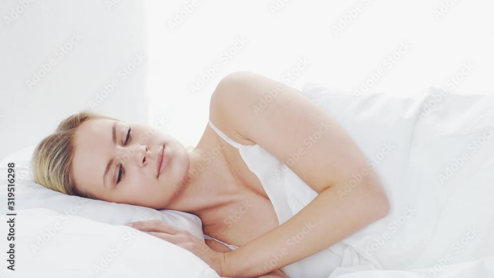 Young woman lying in the bed. Beautiful blond sleeping girl. Morning in the bedroom. Health and rest concept. Young woman lying in the bed. Beautiful blond sleeping girl. Morning in the bedroom. Health and rest concept.