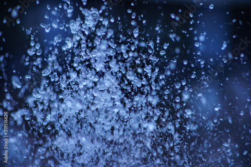 Water drops macro photography. Background is dark and blurry.