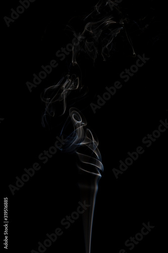 Delicate column of smoke from incense stick isolated on black background, selective focus © Stanislava