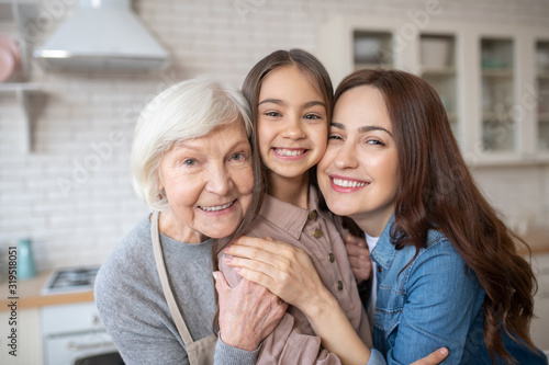 Beautiful and happy woman huggimg her daughter and her mum