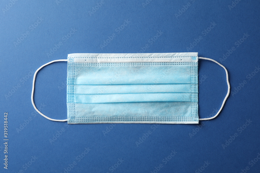 Protective mask on blue background, top view, space for text.Virus protection. Healthcare and medical concept Protective mask on blue background, top view, space for text.Virus protection. Healthcare and medical concept