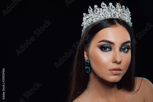 Portrait of beautiful young woman and perfect hair with crown. Closeup face of a pretty model looking at camera. Beautiful woman beauty fashion makeup close up portrait. Smooth hairstyle.