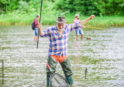 life full of new Hobbies. summer weekend. fisherman with fishing rod. mature man fishing. retired bearded fisher. big game fishing. pothunter. man catching fish. sport activity and hobby. Trout bait