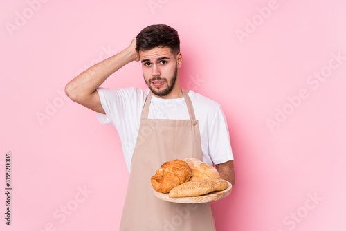 Young caucasian baker man isolated being shocked, she has remembered important meeting.