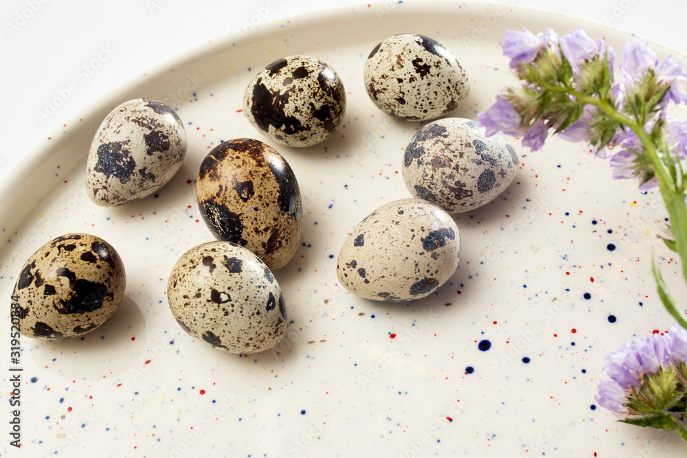 Obraz premium Quail eggs on a white dish. Easter card.