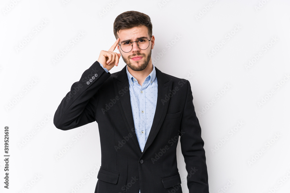Young caucasian business man posing in a white background isolated Young caucasian business man pointing temple with finger, thinking, focused on a task. Young caucasian business man posing in a white background isolated Young caucasian business man pointing temple with finger, thinking, focused on a task.