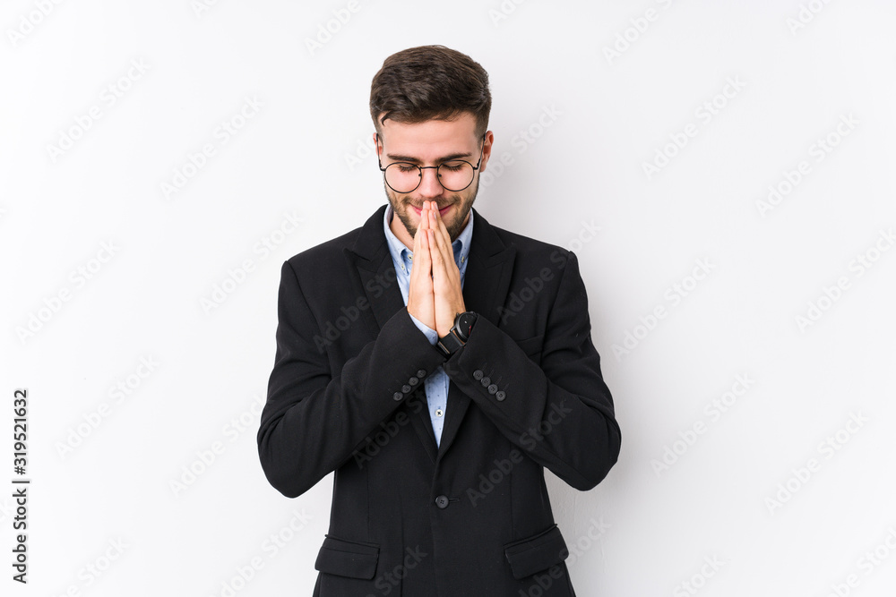 Young caucasian business man posing in a white background isolated Young caucasian business man holding hands in pray near mouth, feels confident. Young caucasian business man posing in a white background isolated Young caucasian business man holding hands in pray near mouth, feels confident.