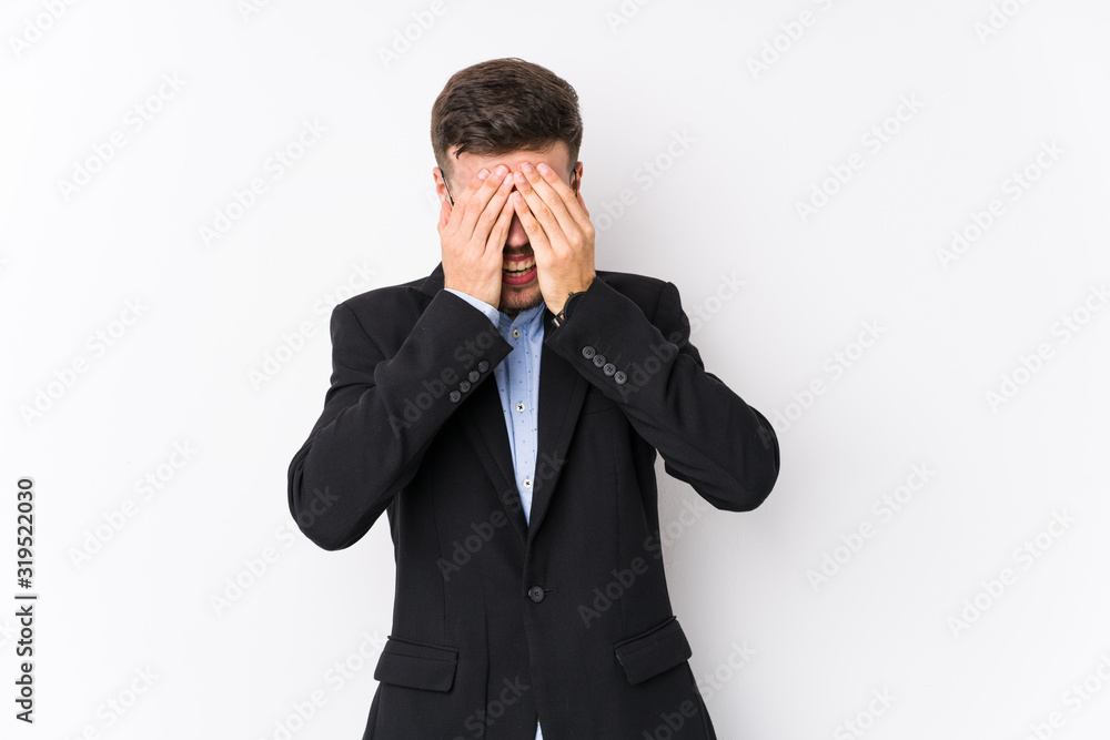 Young caucasian business man posing in a white background isolated Young caucasian business man covers eyes with hands, smiles broadly waiting for a surprise. Young caucasian business man posing in a white background isolated Young caucasian business man covers eyes with hands, smiles broadly waiting for a surprise.