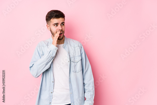 Young caucasian business man posing in a white background isolated is saying a secret hot braking news and looking aside  mixto   © Asier