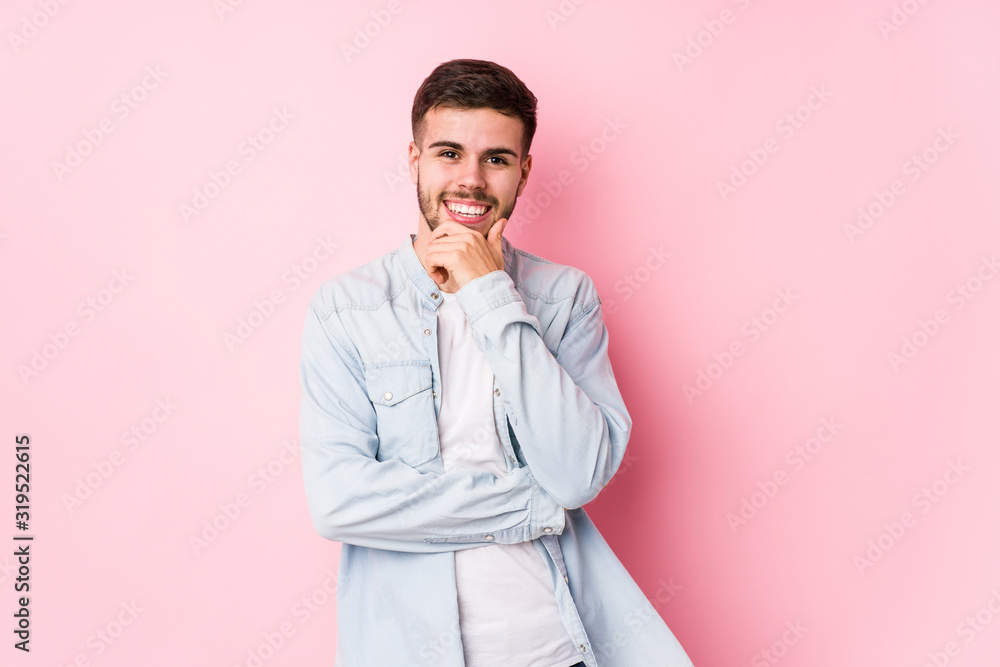Young caucasian business man posing in a white background isolated smiling happy and confident, touching chin with hand.< mixto > Young caucasian business man posing in a white background isolated smiling happy and confident, touching chin with hand.< mixto >