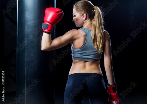 Woman in boxing gloves near a punching bag..