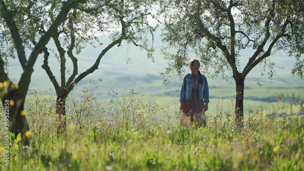 Beautiful girl in romantic dress, denim jacket walks among olive trees. Tuscany Beautiful girl in romantic dress, denim jacket walks among olive trees. Tuscany
