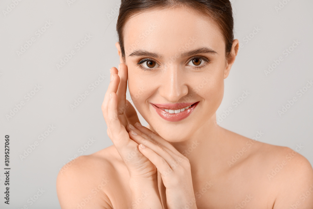 Beautiful young woman with healthy skin on light background Beautiful young woman with healthy skin on light background