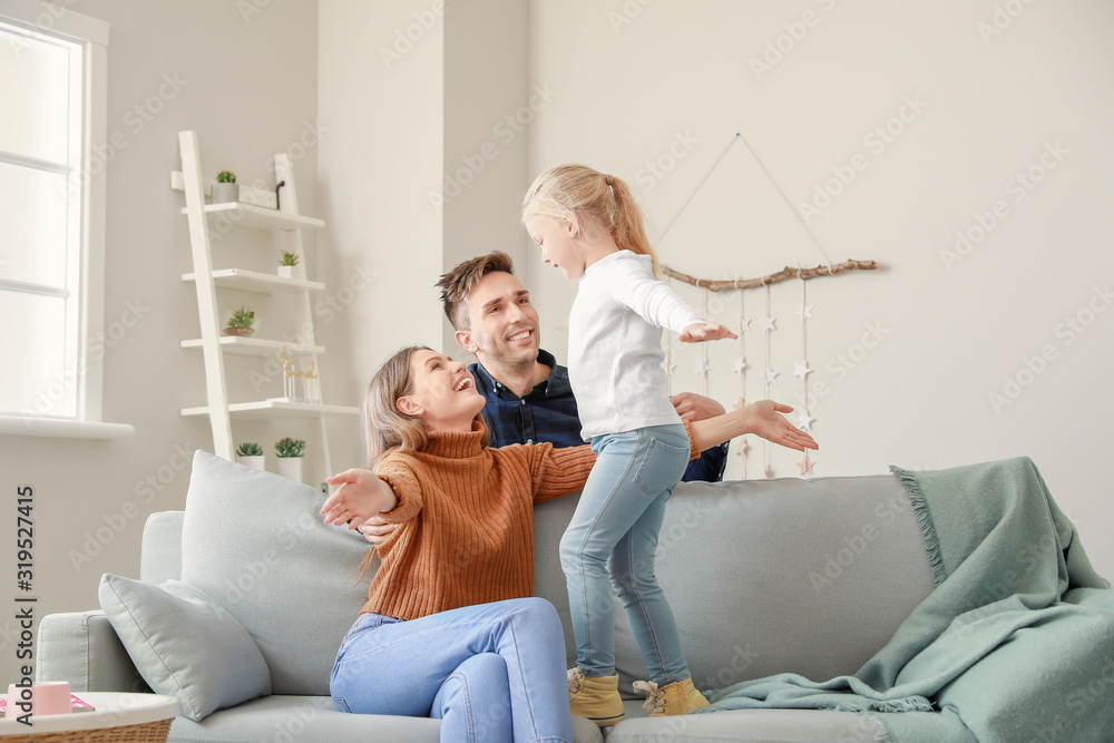 Portrait of happy young family at home - obrazy, fototapety, plakaty 