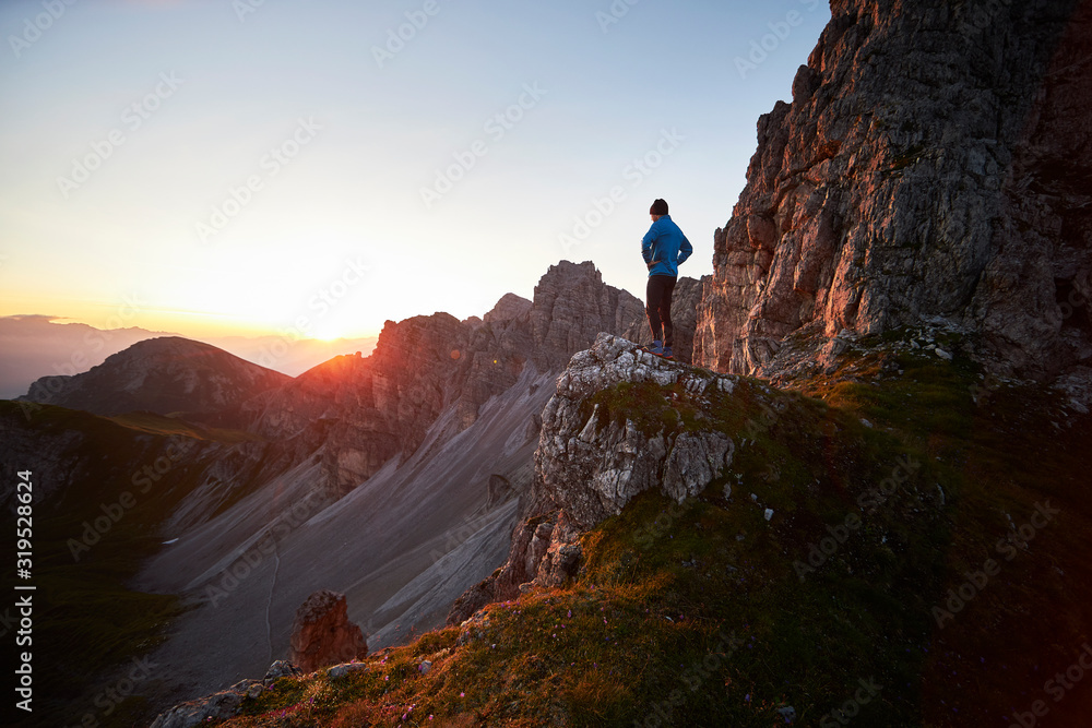 Mountain runner taking a break, watching sunrise at Axamer Lizum, Austria Mountain runner taking a break, watching sunrise at Axamer Lizum, Austria