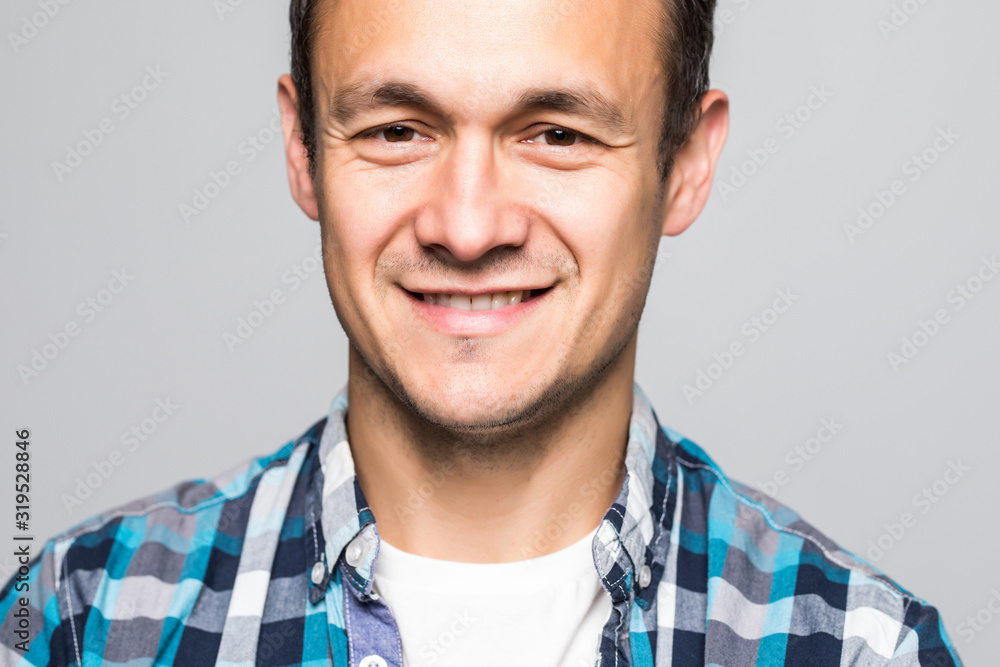 Obraz premium Young smiling optimistic man in t-shirt standing isolated on light gray background