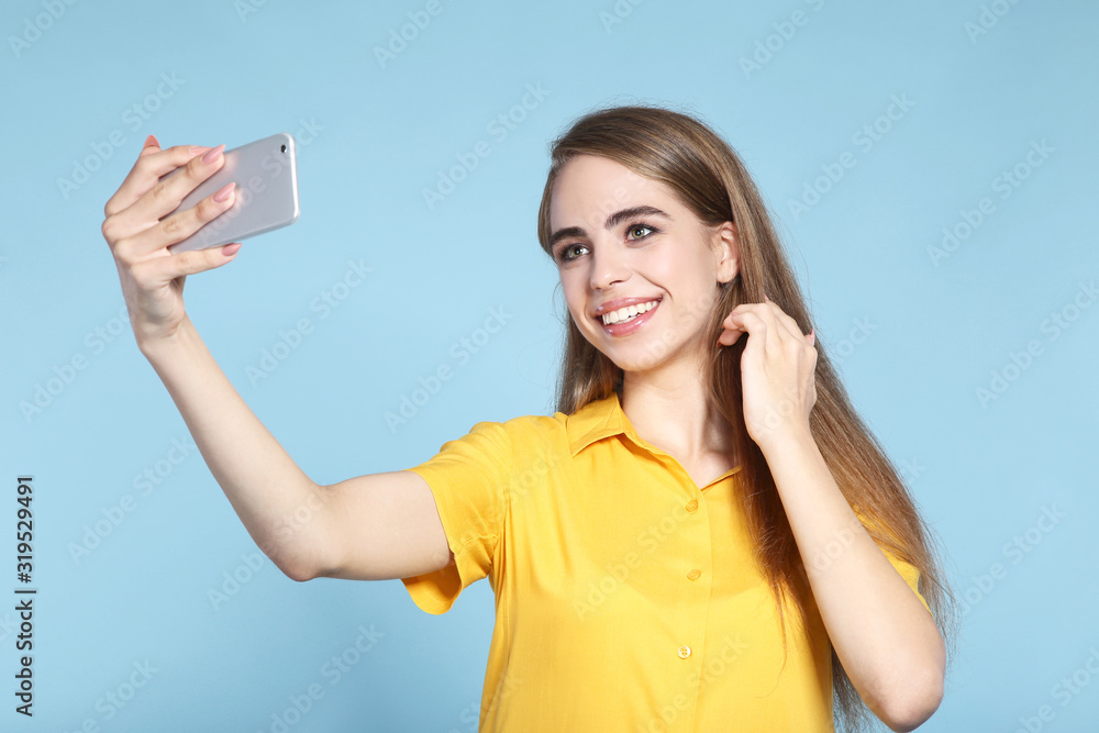 Young beautiful girl making selfie on smartphone
