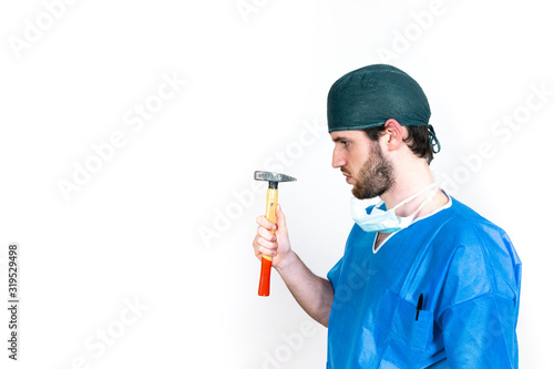 Chirurgo ortopedico con casacca operatoria blu e con martello e sfondo bianco