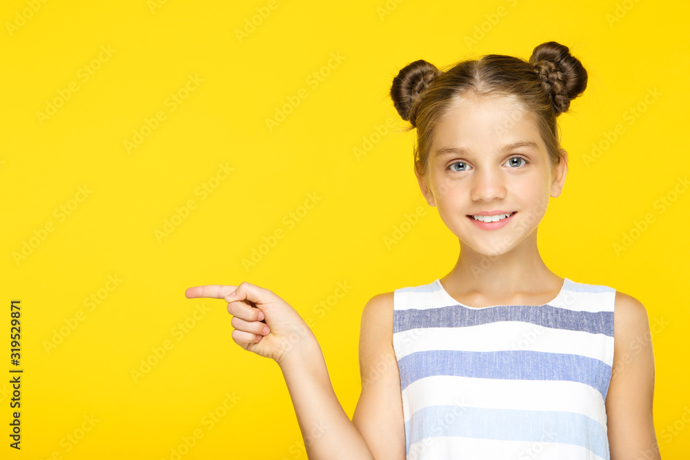 Young beautiful girl pointing by finger on yellow background Young beautiful girl pointing by finger on yellow background