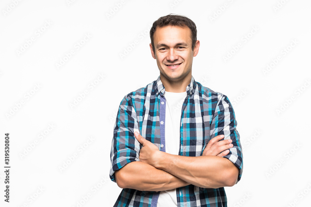 Smiling man standing with arms folded over gray background Smiling man standing with arms folded over gray background