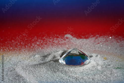 Artificial diamonds lying in the sand photographed in the studio with flash light