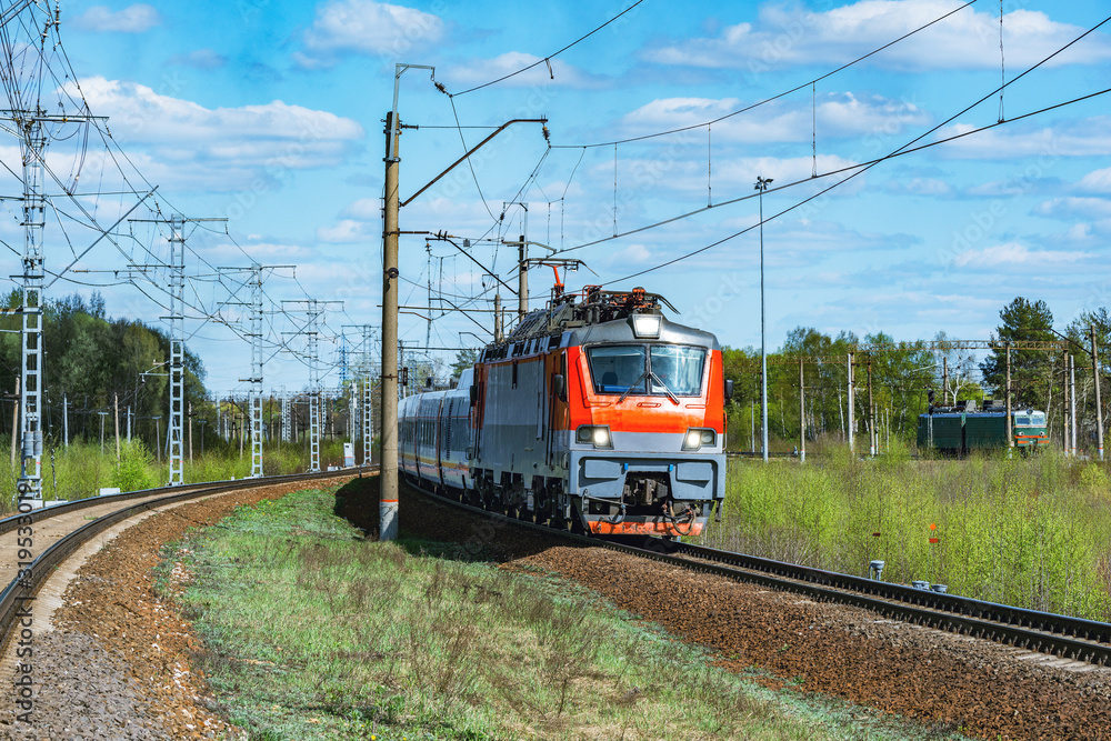 Fototapeta premium Modern high-speed train moves through the station at spring morning time.