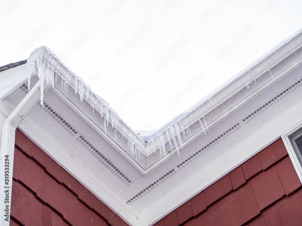 Obraz premium icicles hanging from the roof gutter in winter