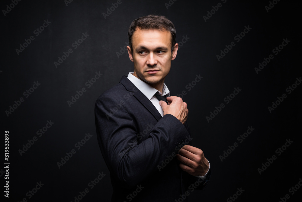 Young handsome businessman on a black background
