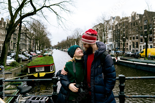 Photography Loving couple man and woman having fun on the streets of Amsterdam in winter warm clothes