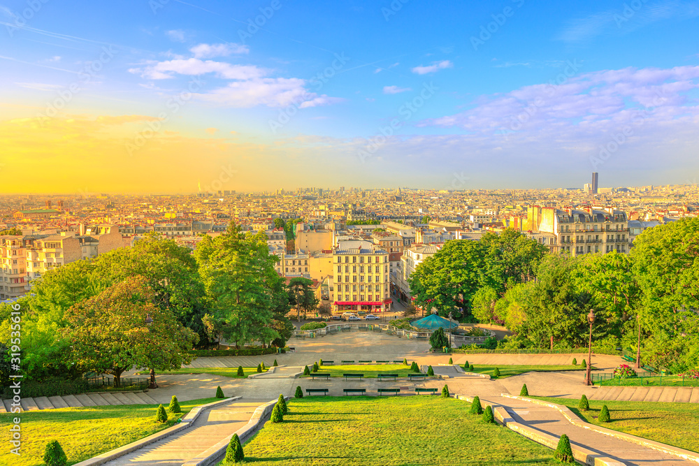 Obraz premium Scenic panorama of Paris at sunset and skyline above Paris. Wide angle view of staircase of Sacred Heart Church from terrace of Cathedral, the highest city point of Paris in Montmartre, France.