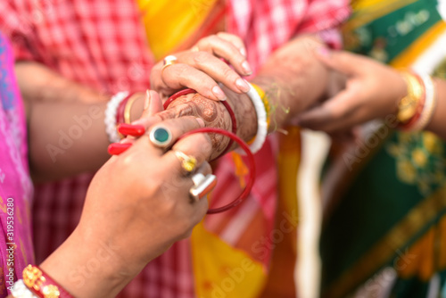 Closeup traditional view of bengali wedding rituals while bride is wearing red bangles in india